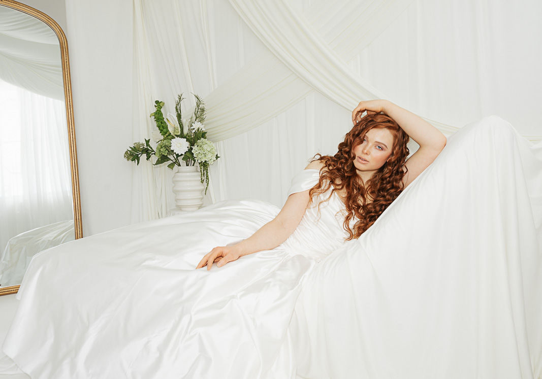 Braut mit roten Haaren, großen Locken und natürlichem Make-up in Rosé-Tönen